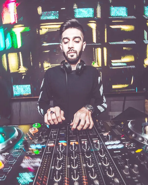 A stylized shot of me fully absorbed in the mix, with the colorful lights of the DJ console reflecting my focus. This is where I blend different sounds to create the perfect party tracklist.