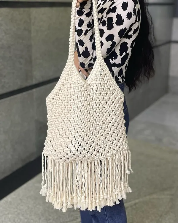 This is my large macrame tote bag in a classic off-white color. It's incredibly spacious and has beautiful fringe detailing at the bottom for that boho touch.
