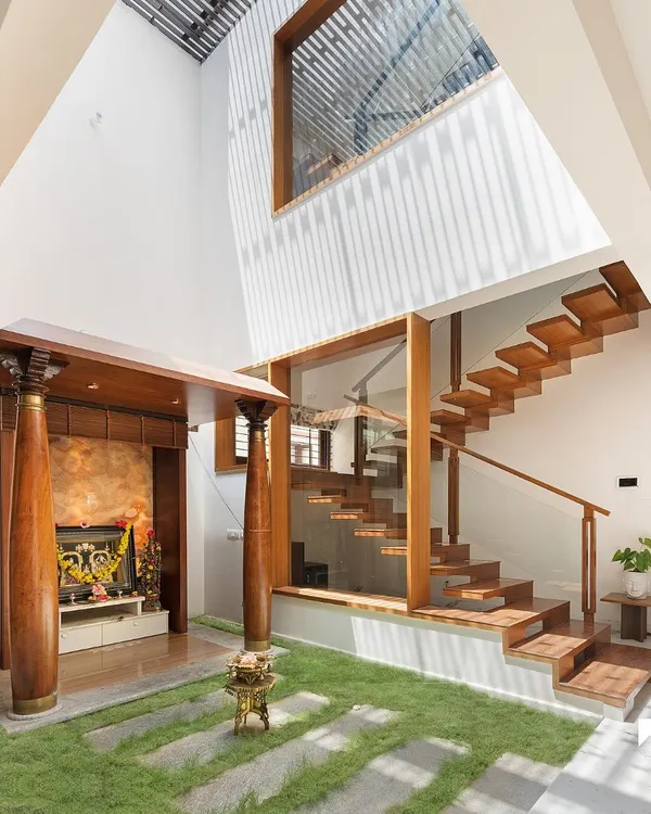 This is the heart of our Twin Courtyard House. We designed this tranquil pooja area to be surrounded by green space and natural light from a double-height skylight, creating a peaceful sanctuary that connects the home's spiritual core with the outdoors.