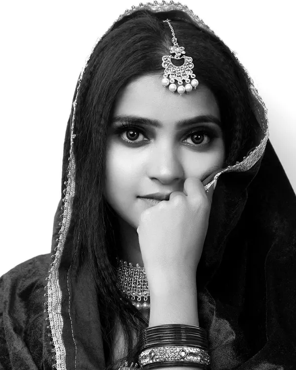 A striking black and white portrait of a model in traditional attire. This type of headshot is essential for a portfolio, showcasing strong expressions and features.