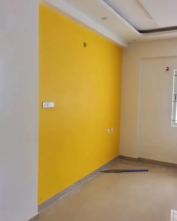A bright and cheerful yellow accent wall in a newly painted room. A single, bold color can completely change the mood and energy of a space.