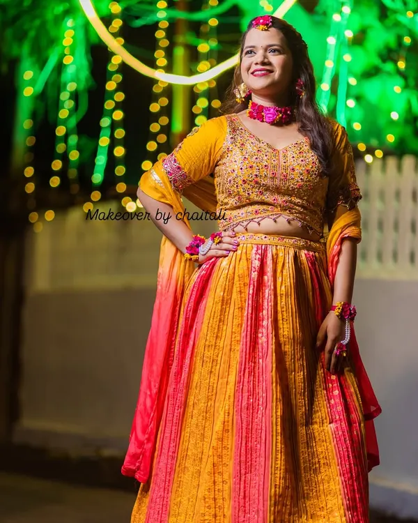 A complete Haldi look for a beautiful bride-to-be. The makeup is bright and glowing to match the festive atmosphere, paired with a simple hairstyle to accommodate floral jewelry.