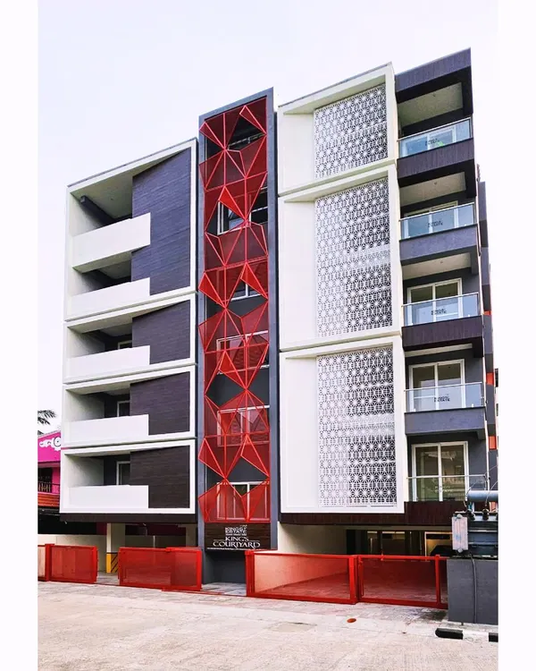 Our "Project R.E.D" in Vellore features a striking red geometric facade made of expanded metal mesh. This design choice gives the residential building a unique identity and functional screening.