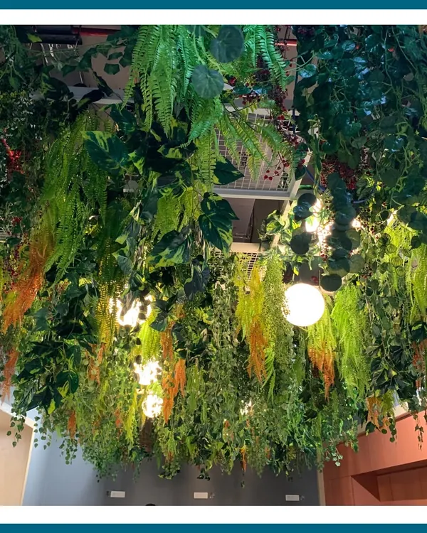 This lush, multi-layered hanging installation creates the feeling of a dense jungle canopy. We used a variety of artificial ferns, vines, and colorful foliage to build a rich, textured overhead garden that transforms the entire atmosphere of the space.