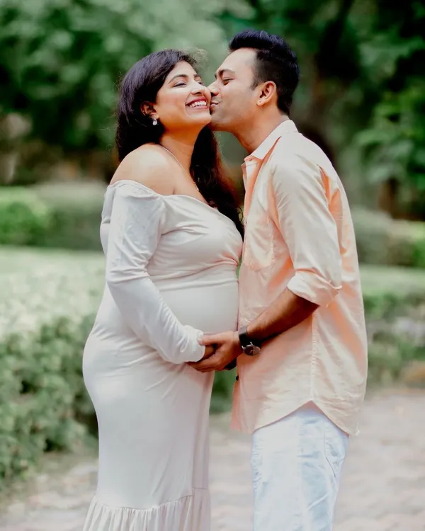 A tender moment during a maternity session, capturing the couple's affection and excitement in a natural park setting. I focus on these quiet, intimate interactions that tell your unique story.