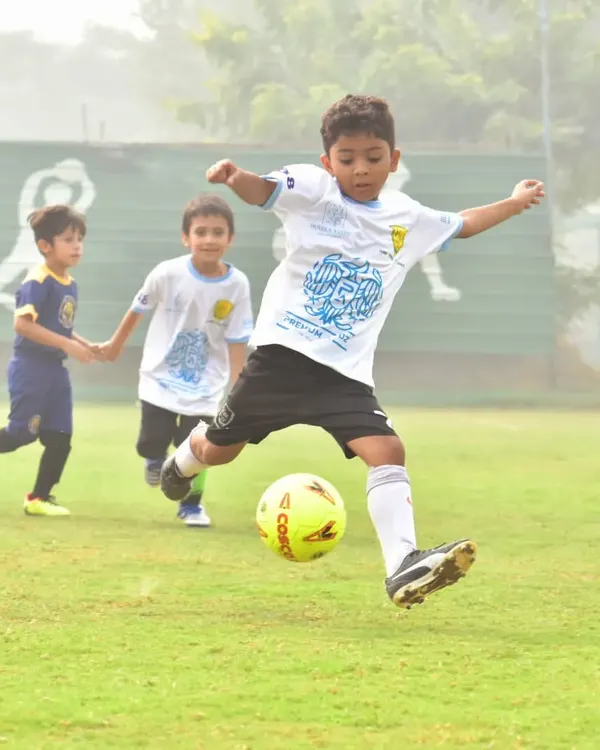 A player takes a powerful shot on goal during the Premium Autoz Football Delhi Golden Baby League.