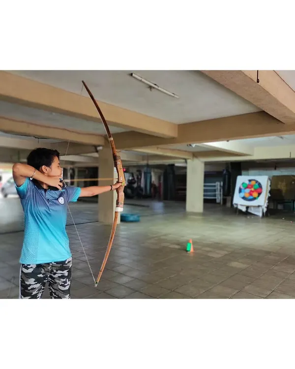 A student from our basic course practices her form with an Indian Bow. We start with fundamentals like stance and anchor point to build a strong foundation.