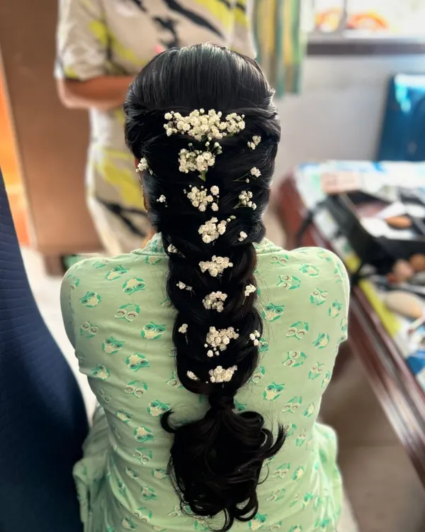 A thick, voluminous braid gets a romantic upgrade with scattered baby's breath. This shows how a simple accessory can completely transform a hairstyle.