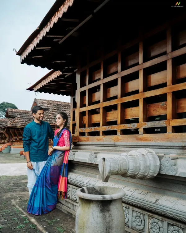 A quiet moment shared between the couple during their traditional pre-wedding shoot. The classic architecture of the Karavali region provides a stunning backdrop for their love story.