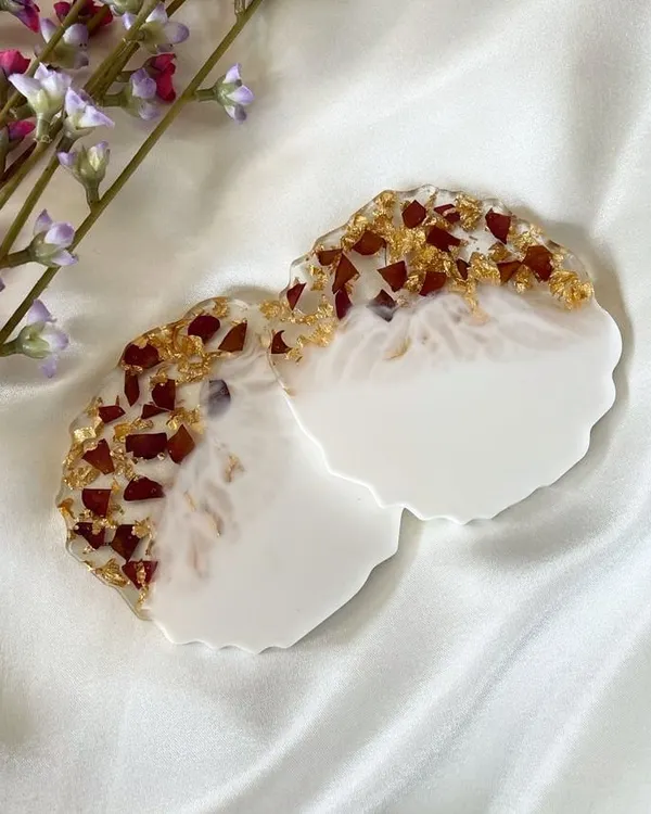These agate-style coasters feature a classic combination of preserved red rose petals and gold flakes against a clean white base. They are perfect for adding a touch of elegance to your coffee table.
