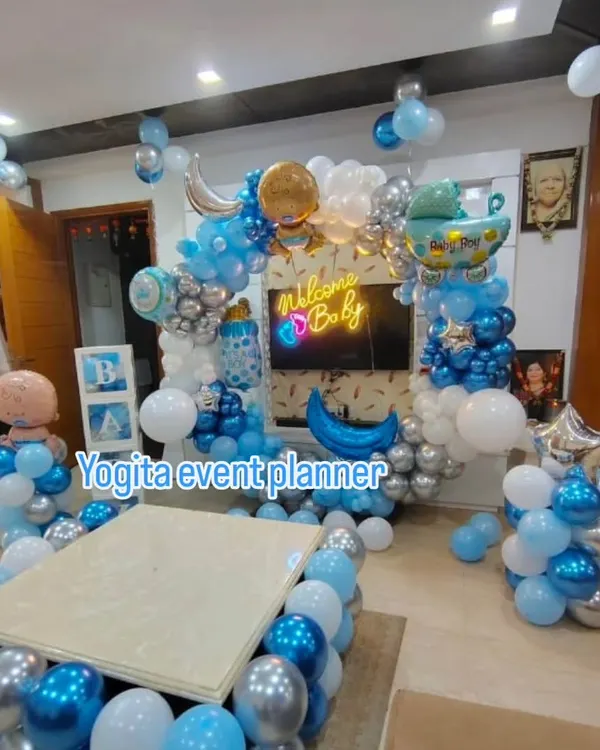 This is the hero item. A complete 'Welcome Baby' room decoration for a baby boy, featuring a custom neon sign, an elaborate balloon arch in shades of blue, white, and silver, and themed foil balloons like a baby bottle and pram.