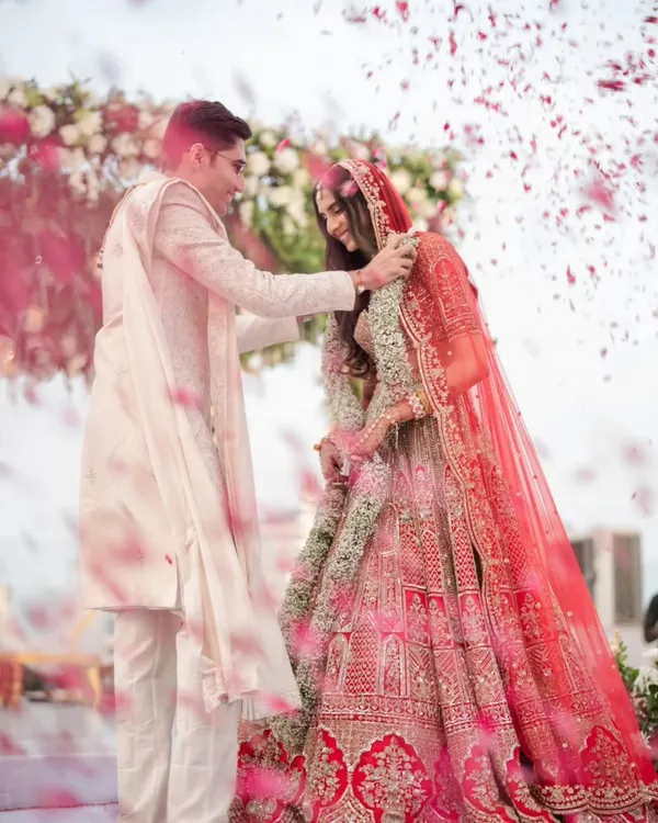 This is the moment it all begins. We capture the pure joy of the Varmala ceremony, with a shower of petals celebrating the union. It's a frame filled with energy, color, and the promise of a beautiful forever.