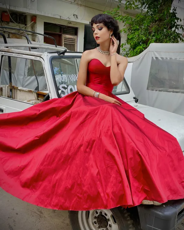 This stunning red ball gown is designed to make an entrance. The structured sweetheart neckline and voluminous skirt create a classic Hollywood-inspired silhouette, perfect for a grand reception or formal event.