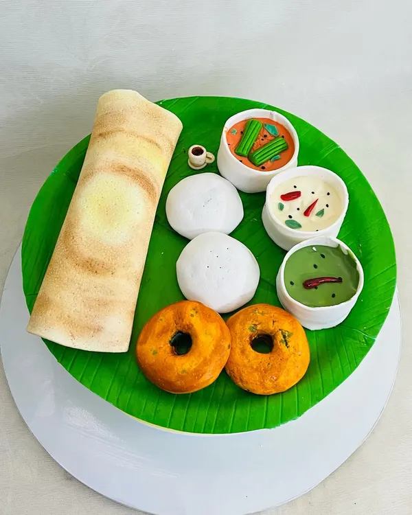 Is it breakfast or is it cake? This is a fully edible South Indian breakfast platter, complete with a dosa, idlis, vadas, and bowls of sambar and chutney, all made from fondant and cake.