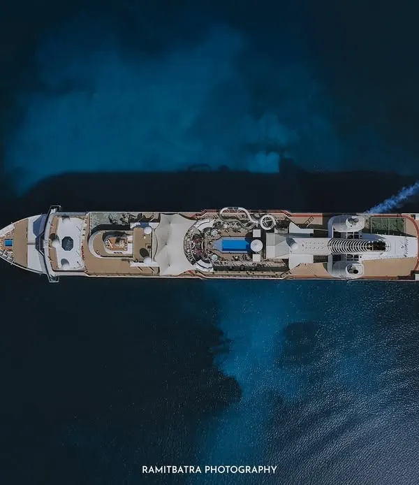 A stunning top-down drone shot of the Resorts World cruise ship sailing on the deep blue sea, showcasing the ultimate destination wedding venue.