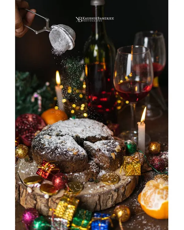 A festive Christmas cake scene, complete with the action of powdered sugar being dusted on top. This shot combines warm, celebratory lighting with a dynamic element to create a truly magical mood.