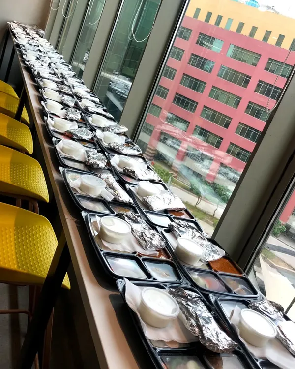 Fueling productivity with our corporate catering service. Here is a large order of packed meal trays being prepared for an office event, ensuring each employee gets a complete and satisfying lunch.