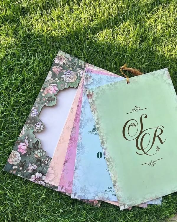 The full experience of a laser-cut invitation. When fanned out, you can see how the intricate floral frame of the cover perfectly complements the pastel-colored inserts for each event.