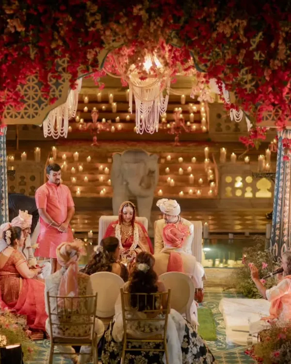 A mandap floating on water at Nahargarh Palace, designed for a moment of serene splendor. Under a canopy of red bougainvillea and the glow of countless candles, this setting was crafted to feel both regal and deeply intimate, a true sanctuary for sacred vows.