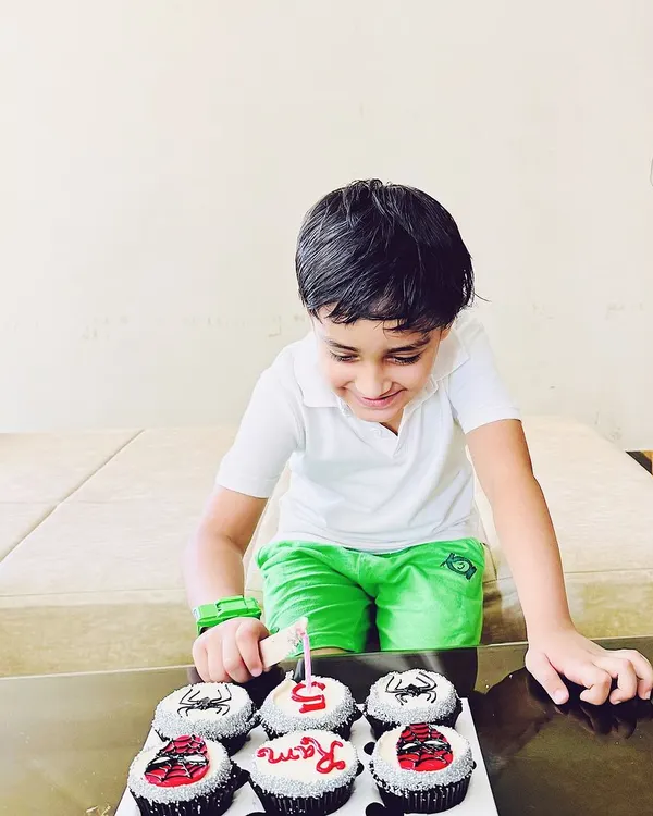 The birthday boy, Ram, getting ready to make a wish on his 5th birthday. His custom Spider-Man cupcakes are all lined up, showing the complete themed set that includes his name and age.