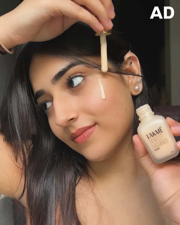 A close-up shot demonstrating the Lakmé Perfect Radiance Serum. I focus on showing the product's texture and application to highlight its skincare benefits, like fading pigmentation with Niacinamide.