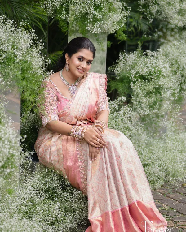 This client looks breathtakingly beautiful in her pastel pink saree for her engagement. I designed a matching blouse with 3D floral embroidery to create a look of modern romance.