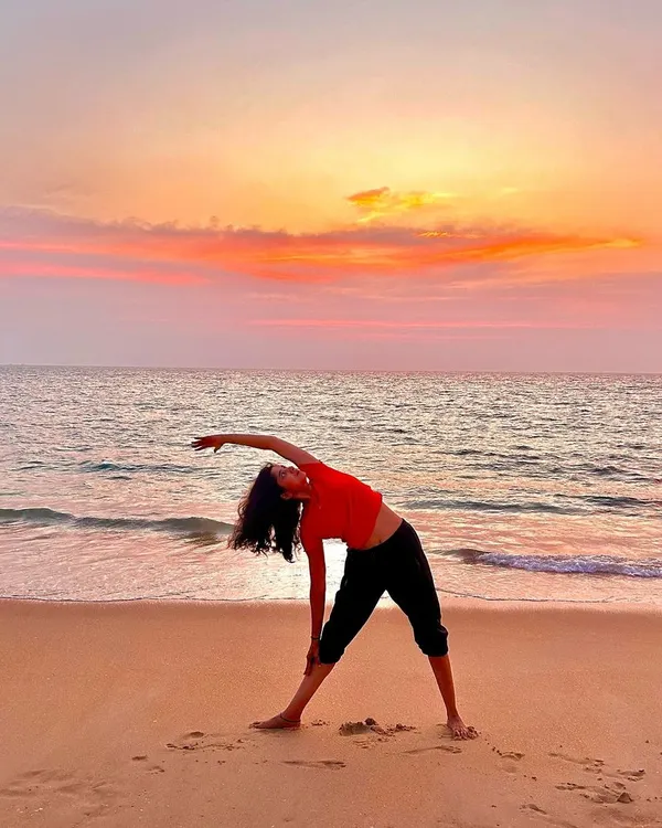 This is the feeling I want you to have. Finding your balance with Trikonasana, or Triangle Pose, as the sun sets over the ocean. It's a beautiful way to stretch the entire body and find a moment of calm.