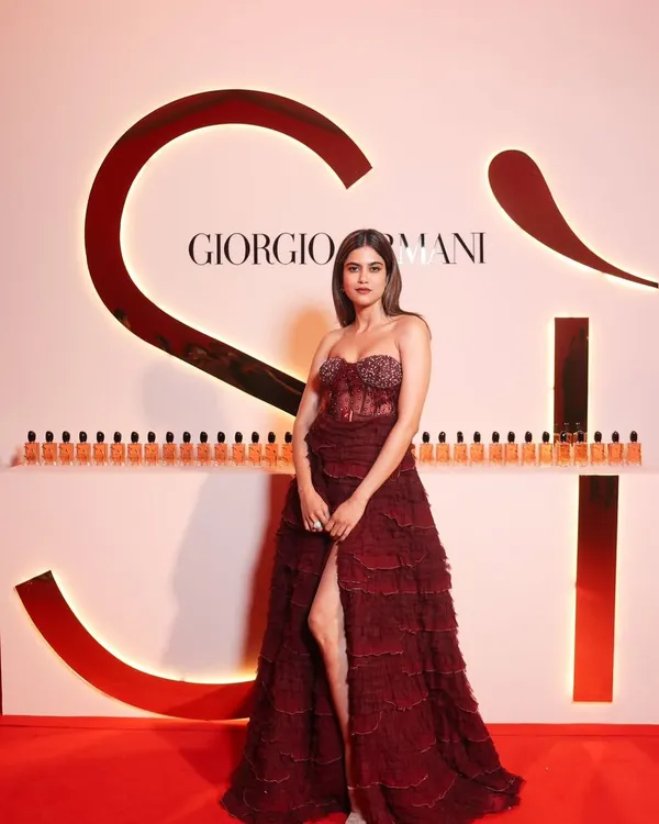 A full-length shot of Aaditi Pohankar at the Giorgio Armani event. The deep red gown called for a powerful makeup look with a bold lip and sculpted eyes.