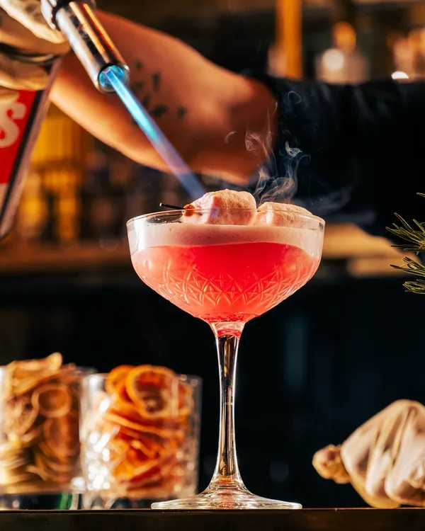 The perfect end to a perfect meal. Our bartenders use fire to toast marshmallows atop this pink cocktail, adding a touch of sweet, smoky drama.