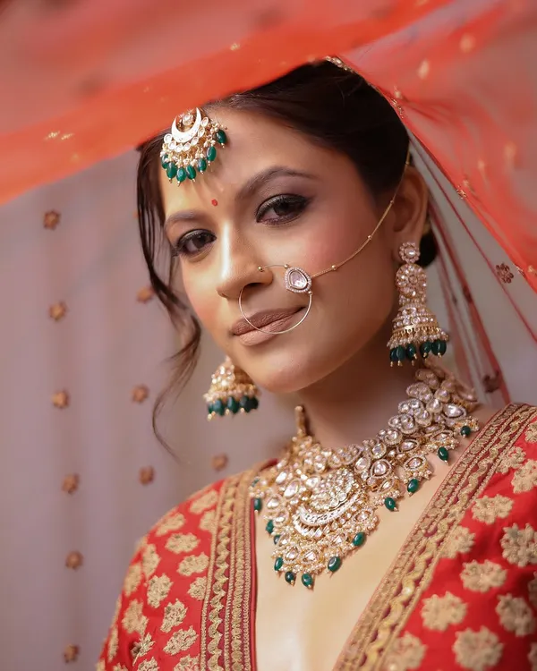 A classic Indian bride, radiant under her veil. This look is all about timeless elegance, with soft, glowing skin and eyes that tell a story of love and tradition. This is the quintessential bridal dream I bring to life.