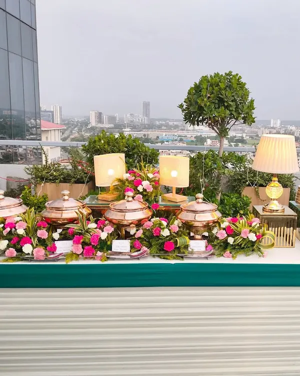 An exquisite rooftop buffet with a panoramic view of the city. We use a combination of ambient lighting, floral decor, and elegant serveware to create a luxurious dining experience.