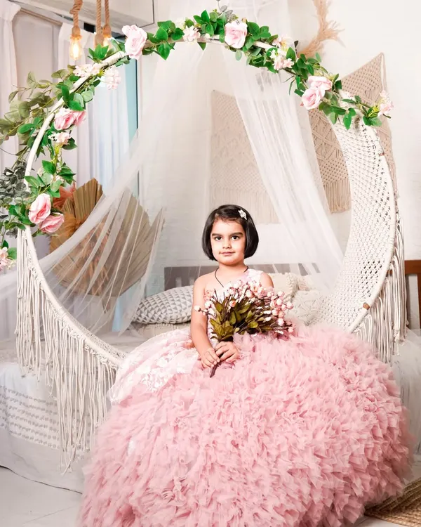 Your little girl can have her princess moment in this beautiful pink ruffled ball gown. This was shot in my studio's boho-chic setup with a hanging chair, creating a dreamy, fairytale look.