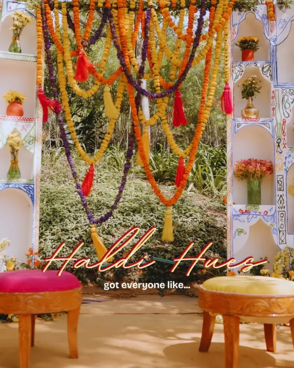 The focal point of a vibrant Haldi ceremony, this backdrop features a traditional 'jhoola' (swing) adorned with colorful marigold garlands and tassels, creating the perfect spot for the main ritual.