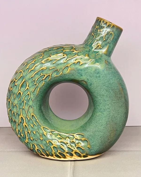 This textured turquoise donut vase is a real showstopper. The carving on the surface adds a tactile dimension, while the hole in the center creates a modern, sculptural feel.