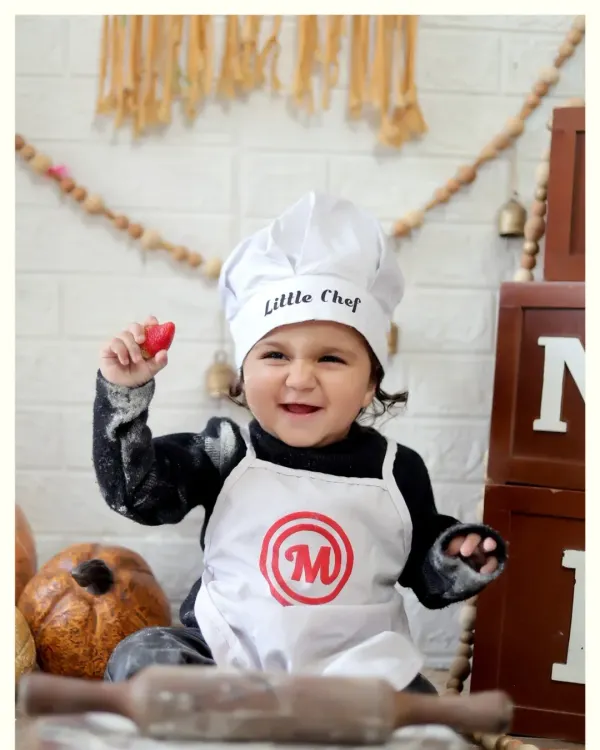 A joyful moment from our 'Little Chef' photoshoot. We use fun props like flour and rolling pins to create an interactive and delightful experience for your child.