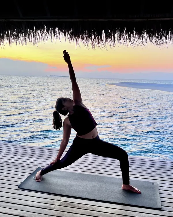 Holding Reverse Warrior pose against a beautiful sunset. This pose strengthens the legs and core while creating a beautiful side body stretch, making you feel both powerful and peaceful.