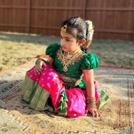 A beautiful shot of a custom-designed Pattu Pavadai in green and pink. I used pure silk and added delicate embroidery on the puffed sleeves to give it a rich, couture feel perfect for a little princess.