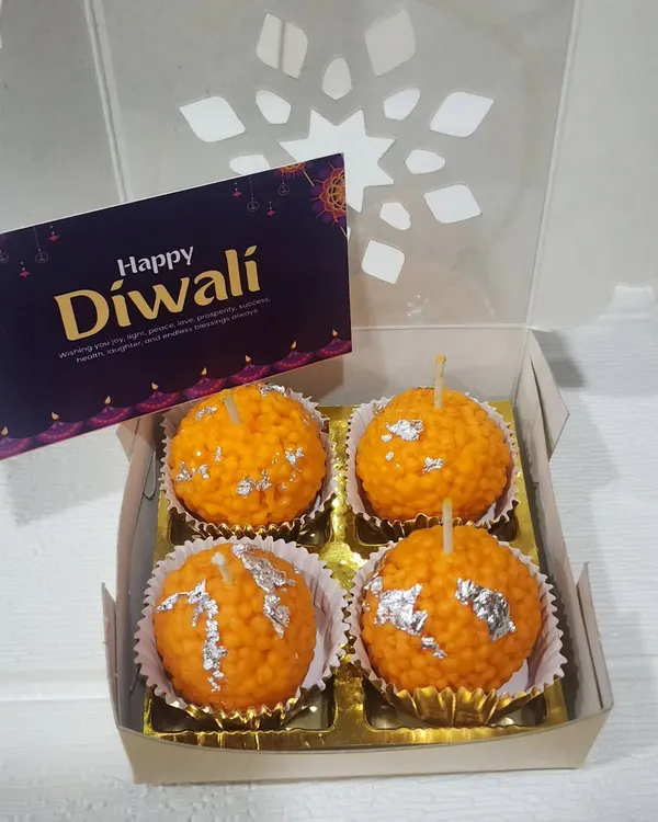 This gift box contains four of my signature Motichoor Ladoo candles. Each one is handcrafted to look just like the real sweet, complete with silver leaf detail, and made with scented soy wax for a clean burn.