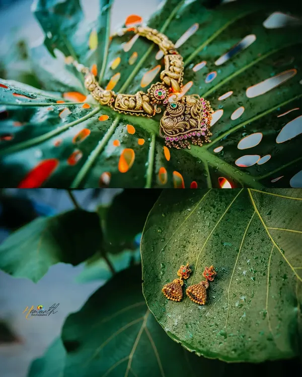 A creative shot of the bride's traditional temple jewelry, artistically placed on large green leaves. This highlights the intricate craftsmanship of the pieces.