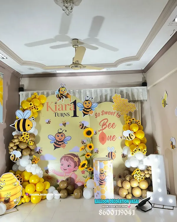 A cheerful "Bumble Bee" theme for a first birthday. The bright yellow and white balloon decor, along with cute bee cutouts, creates a sunny and happy atmosphere.