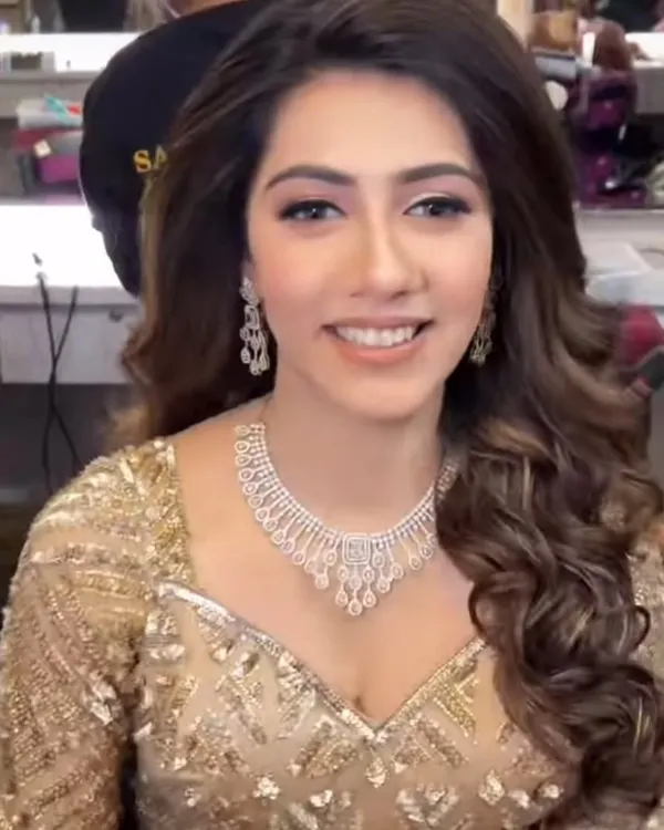 A smiling model wearing a delicate American Diamond necklace set. This elegant and understated piece is perfect for a reception or engagement party.