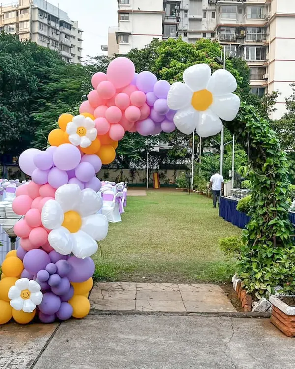 We created this vibrant, full-sized balloon arch to serve as a magical entrance for an outdoor garden party. The design features a pastel rainbow of balloons accented with large and small daisy foil balloons, perfectly framing the venue entryway.