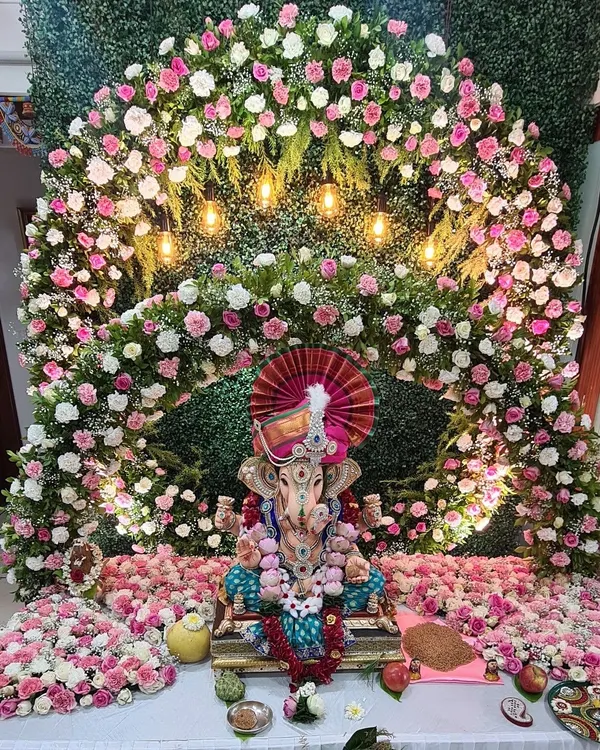 A truly grand floral arch for a beloved Ganpati idol. This massive arrangement uses thousands of pink and white flowers against a green wall, with warm lights that make the entire setup look divine and welcoming.