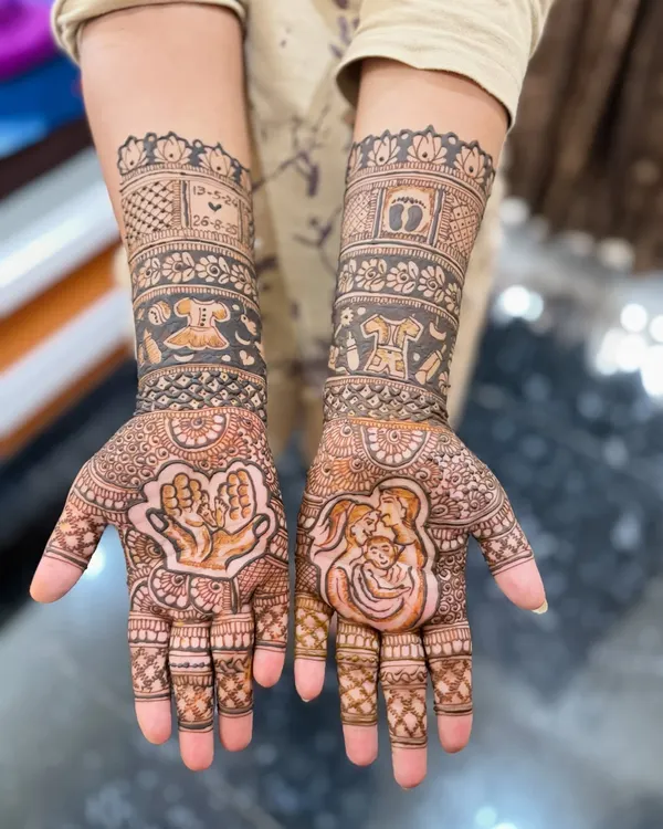 A detailed look at a custom baby shower mehendi design. This features a portrait of the new family, baby clothes, and the due date, all woven into traditional patterns. It's a beautiful way to capture the excitement of this special time.