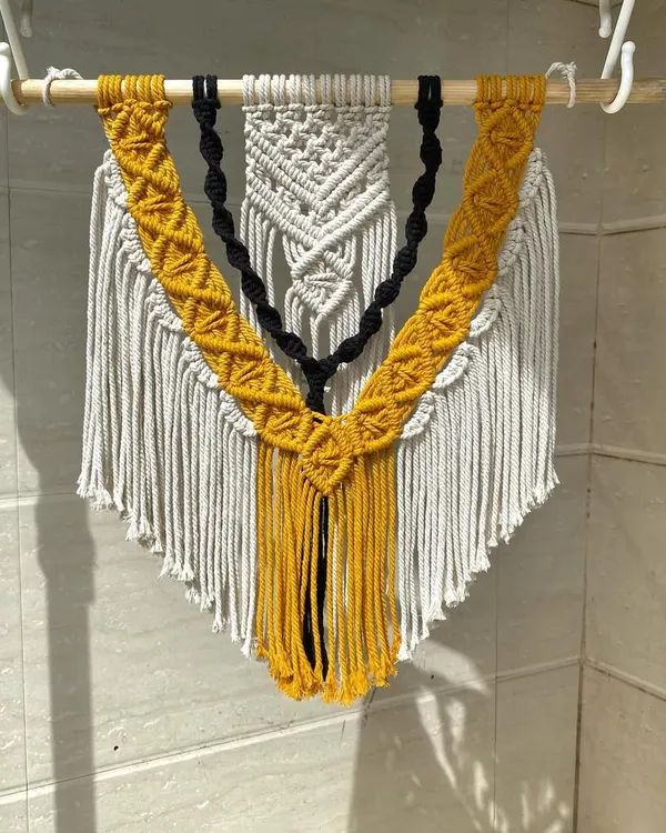 A full view of our custom three-layered macrame wall hanging. The combination of intricate knots and layered colors creates a piece with amazing depth and texture, perfect for a statement wall.