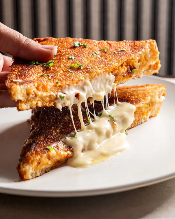 The anatomy of a perfect grilled cheese sandwich. Capturing a cheese pull like this is a guaranteed way to boost engagement on social media.
