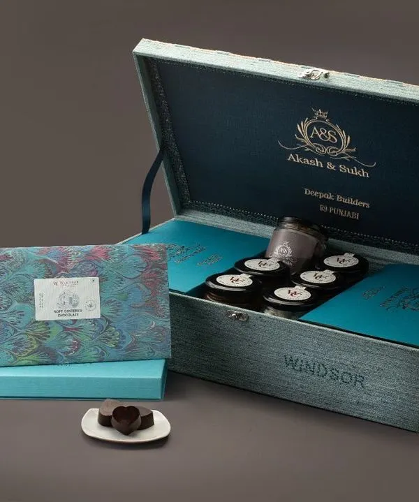This custom wedding box for 'Akash & Saloni' is a prime example of my luxury gifting service. It features a personalized wooden chest, custom inserts, and a curated selection of our finest couverture chocolates, making it a perfect wedding announcement or favor.