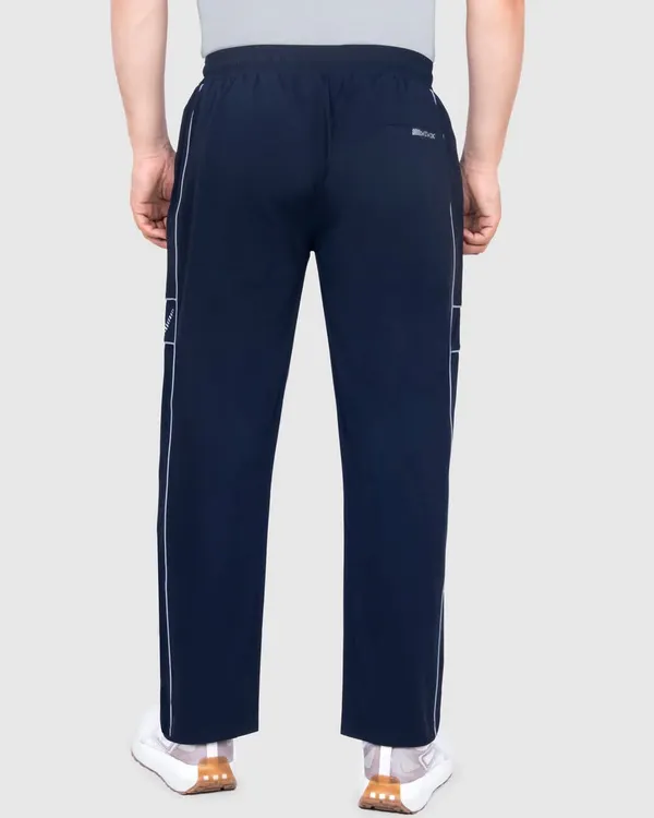 A back view of a model wearing navy sportswear track pants, shot on a clean grey background. This ghost mannequin style is perfect for e-commerce listings, showing the fit and design clearly.