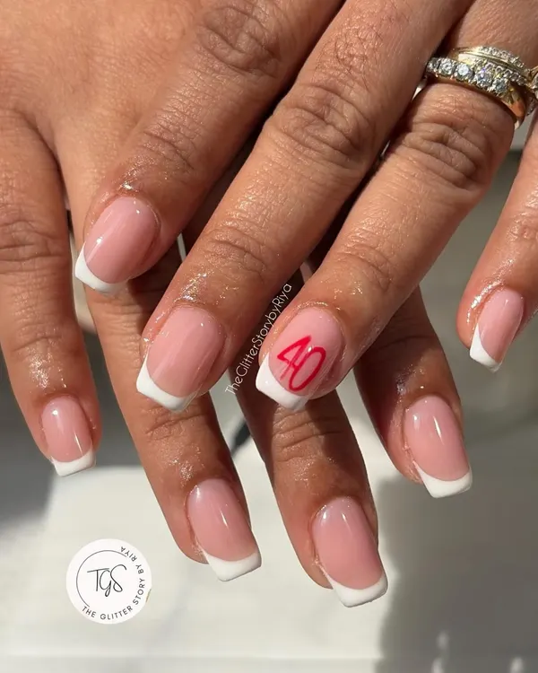 A classic French manicure with a personal touch. This client wanted to celebrate a milestone, so we added the number '40' in a clean, red script to the accent nail.