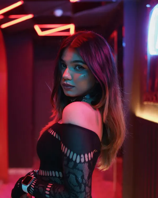 A shot from a photoshoot in a neon-lit corridor. My style is a mix of edgy and trendy, which reflects the modern sound I bring to my DJ sets.